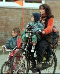 Diewertje Blok met haar kinderen fietsend door Amsterdam