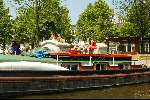 Woonboot aan grachten van Amsterdam
Sloepenroute
Bankstel met daarop mensen die een hapje eten en een glaasje drinken
